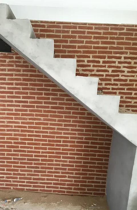 Escalier en béton contre un mur de brique