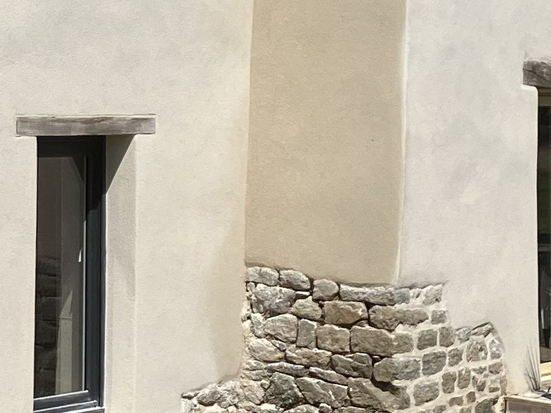 Soubassement en pierre sous un enduit à la chaux