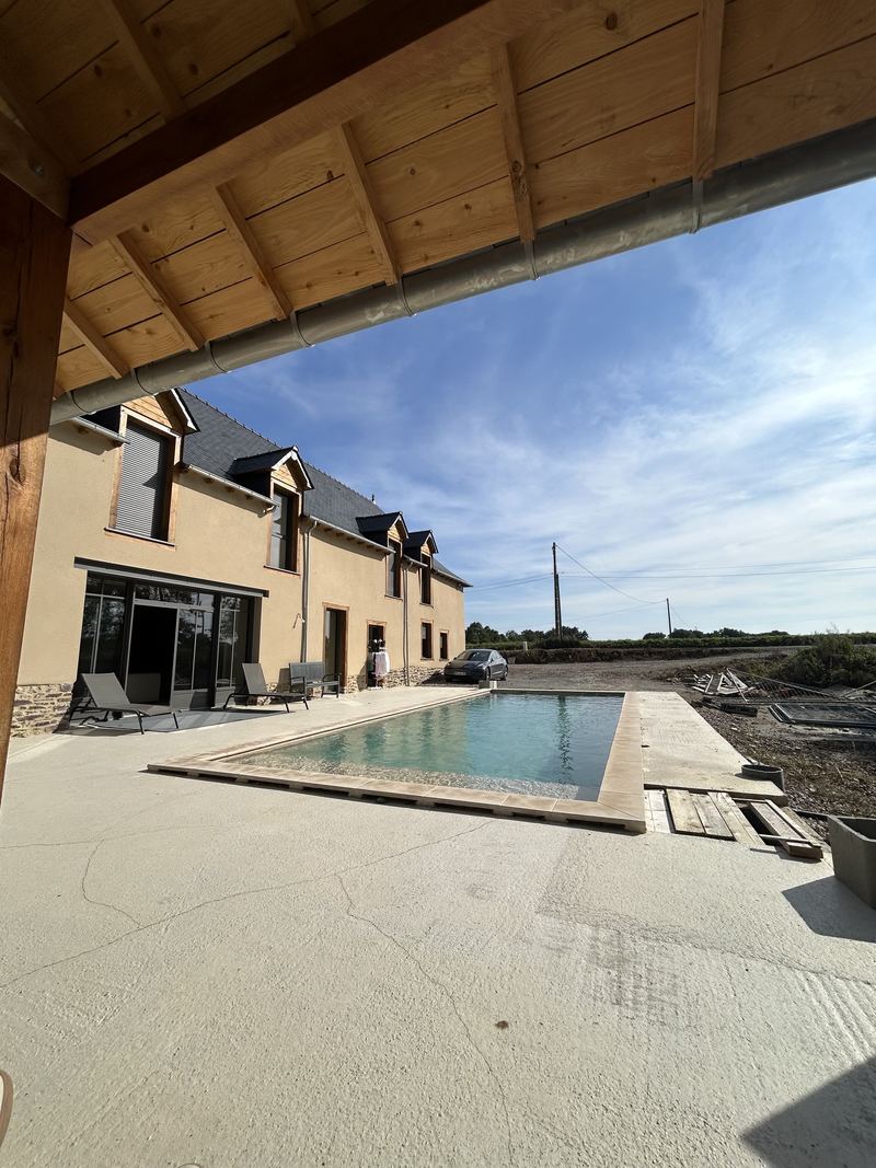 Terrasse et plage de piscine sous une charpente en bois